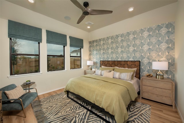 bedroom featuring visible vents, an accent wall, baseboards, recessed lighting, and wood finished floors