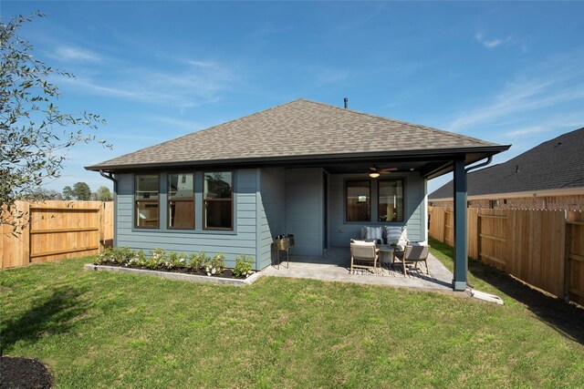 rear view of property featuring a fenced backyard, a lawn, a shingled roof, and a patio