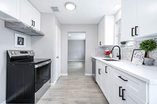 kitchen with visible vents, a sink, decorative backsplash, light countertops, and stainless steel appliances