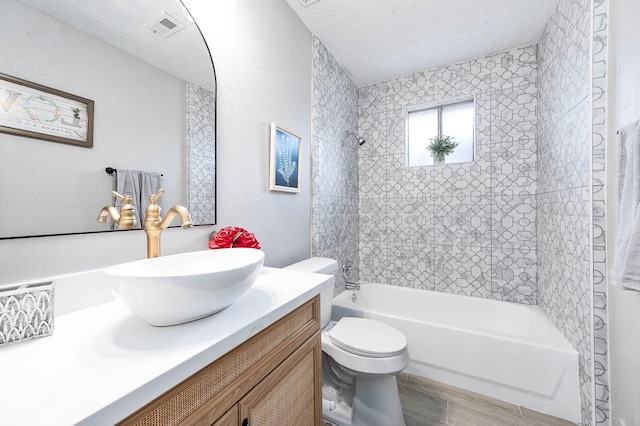 bathroom with visible vents, toilet, shower / tub combination, a textured ceiling, and vanity