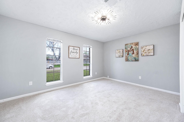 spare room with visible vents, baseboards, carpet floors, and a textured ceiling