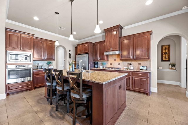 kitchen with light tile patterned floors, visible vents, arched walkways, and stainless steel appliances