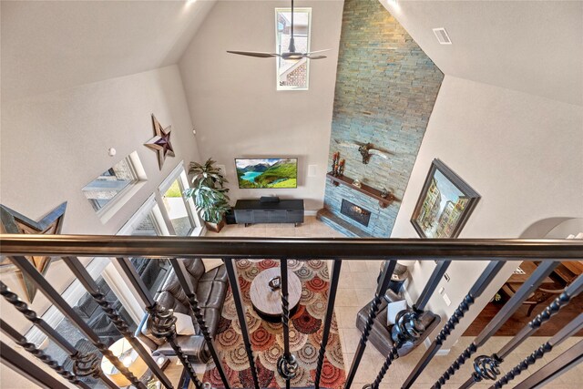 stairway featuring a ceiling fan, visible vents, and high vaulted ceiling