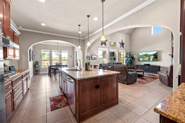 kitchen with a sink, open floor plan, light tile patterned floors, arched walkways, and stainless steel dishwasher