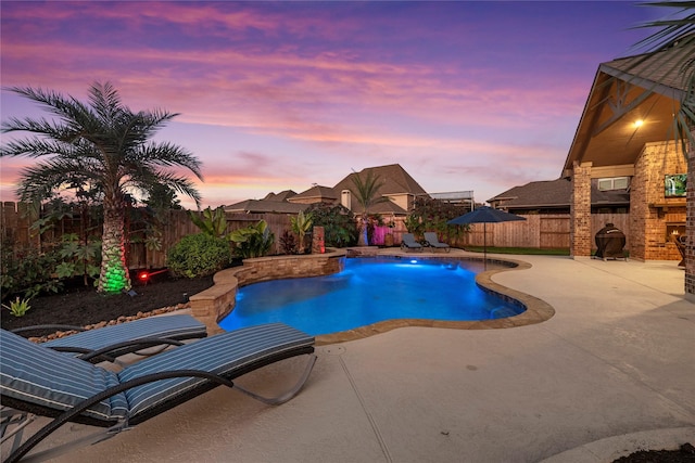 pool at dusk with a fenced backyard, a fenced in pool, and a patio