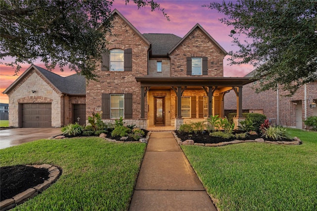 view of front of house featuring a lawn, concrete driveway, an attached garage, a shingled roof, and brick siding