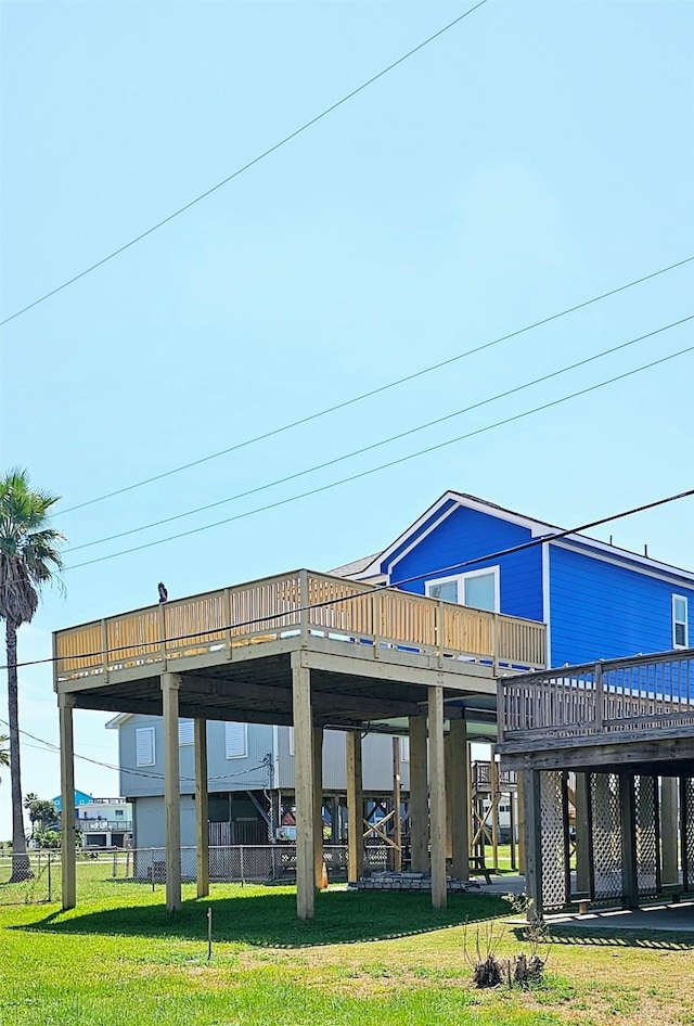 back of property featuring a wooden deck and a lawn