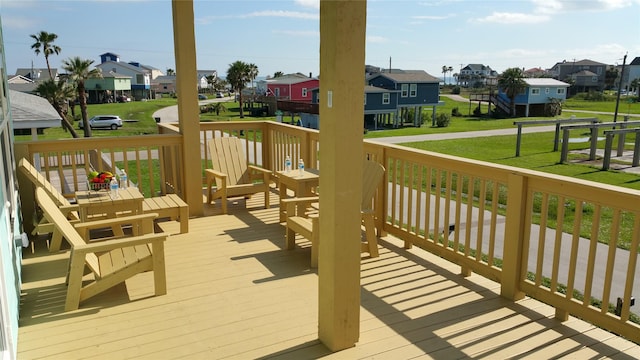 wooden deck with a residential view and a lawn