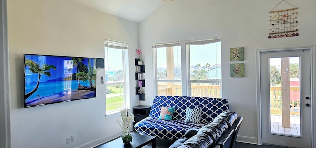 living area featuring lofted ceiling and baseboards