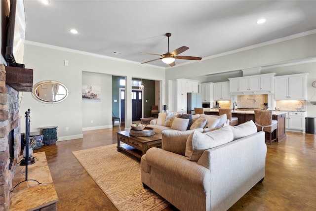 living room featuring crown molding, baseboards, concrete flooring, a stone fireplace, and a ceiling fan