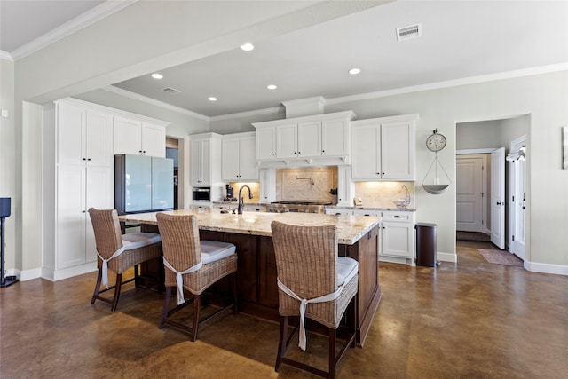 kitchen featuring tasteful backsplash, visible vents, finished concrete flooring, baseboards, and freestanding refrigerator