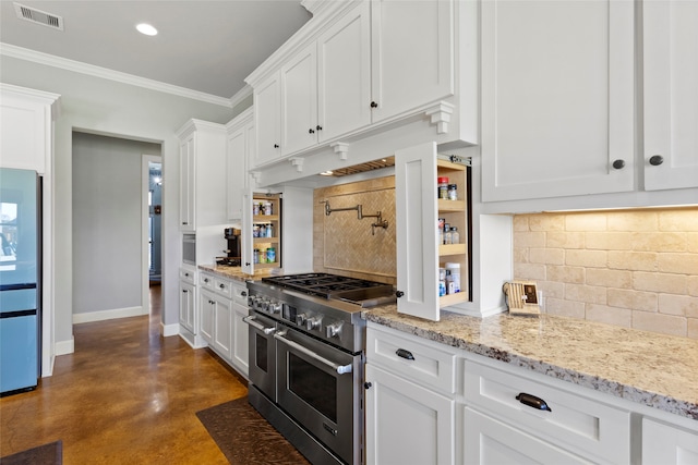 kitchen with white cabinets, double oven range, visible vents, and baseboards