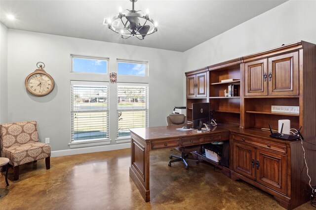 office with a wealth of natural light, an inviting chandelier, concrete flooring, and baseboards