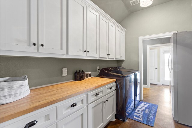 washroom featuring visible vents, cabinet space, and washing machine and dryer