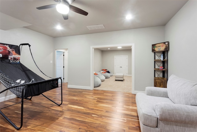 sitting room with a ceiling fan, wood finished floors, visible vents, baseboards, and recessed lighting