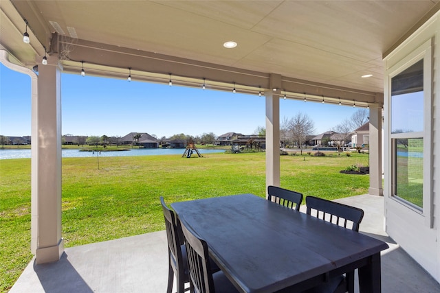 view of patio with a water view and outdoor dining space