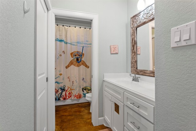 bathroom with vanity, curtained shower, toilet, and a textured wall