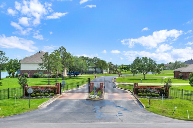 view of community featuring fence, a yard, and a gate