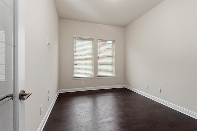 empty room featuring dark wood finished floors and baseboards