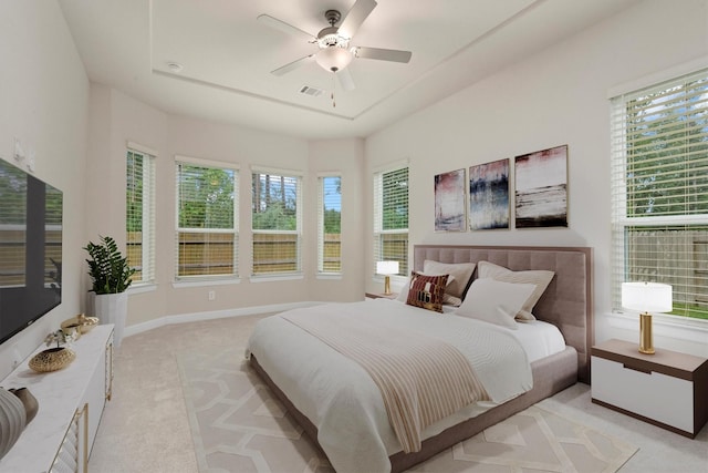 bedroom with a ceiling fan, light colored carpet, visible vents, and baseboards