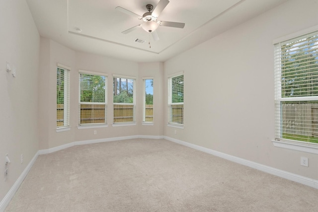 unfurnished room featuring visible vents, light carpet, baseboards, and ceiling fan