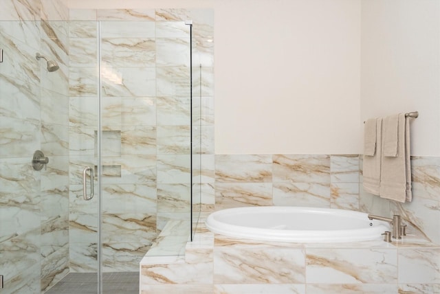 full bath featuring a stall shower and a garden tub