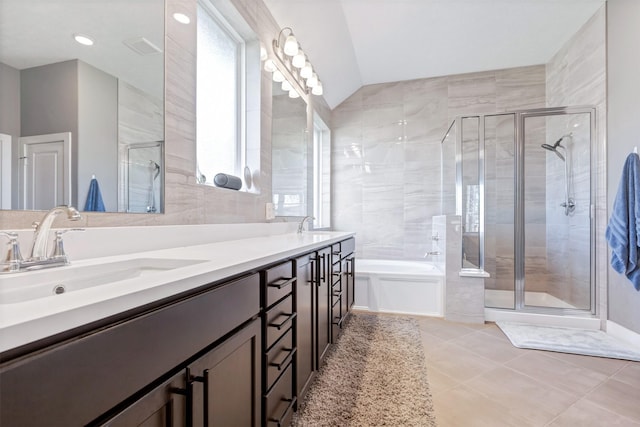 full bath with tile patterned flooring, double vanity, a stall shower, a bath, and a sink