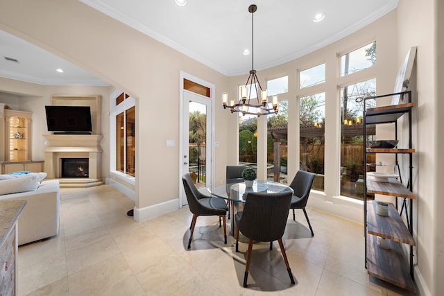 dining area with baseboards, a lit fireplace, and ornamental molding