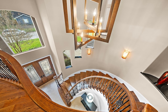 stairway featuring french doors and a high ceiling