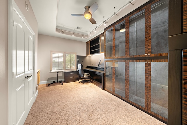 carpeted office featuring baseboards, visible vents, built in study area, ceiling fan, and rail lighting