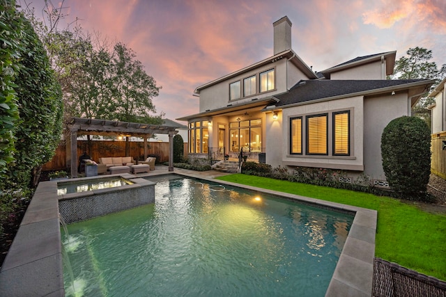 back of house at dusk with fence, an outdoor living space, a pergola, stucco siding, and a patio area