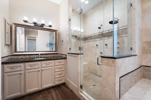 full bathroom featuring wood finished floors, a stall shower, and vanity