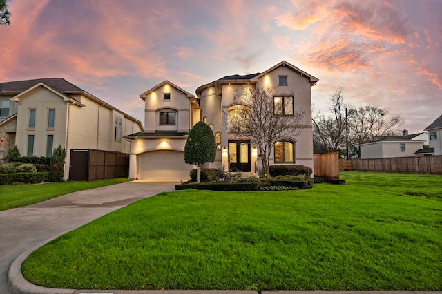 view of front of home with fence, a garage, driveway, and stucco siding