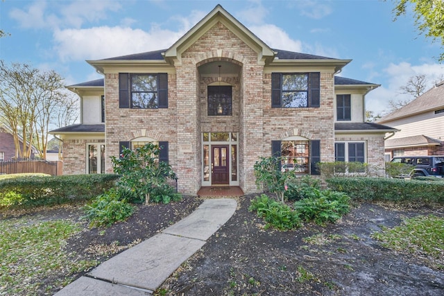 traditional home with brick siding and roof with shingles