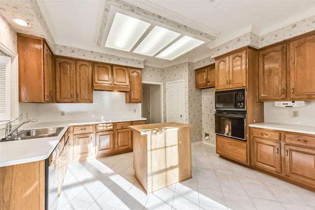 kitchen featuring wallpapered walls, a sink, black appliances, light countertops, and brown cabinets