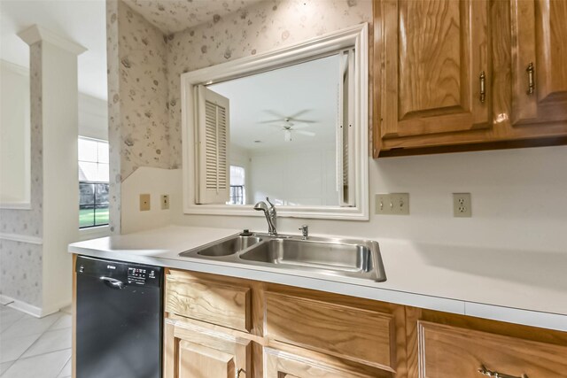 kitchen with wallpapered walls, light countertops, black dishwasher, light tile patterned floors, and a sink