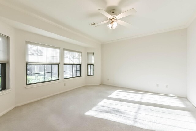 spare room featuring carpet flooring, a ceiling fan, crown molding, and baseboards