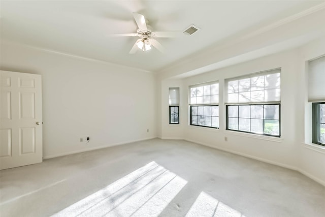 unfurnished room with ceiling fan, light colored carpet, visible vents, and baseboards