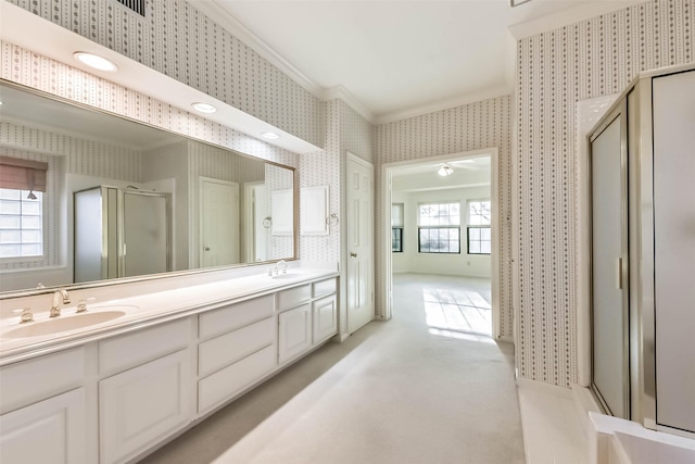 full bathroom featuring a stall shower, wallpapered walls, crown molding, and a sink