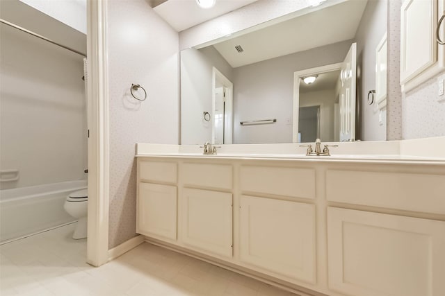 full bathroom with visible vents, toilet, a sink, wallpapered walls, and double vanity