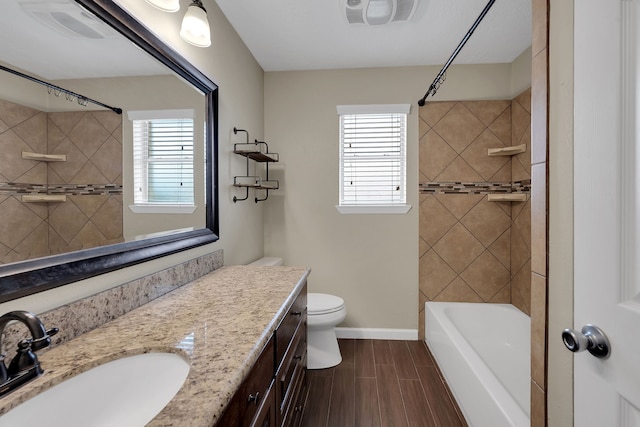 full bath featuring vanity, plenty of natural light, visible vents, and wood tiled floor