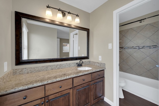 full bathroom featuring baseboards, toilet, bathtub / shower combination, wood finished floors, and vanity