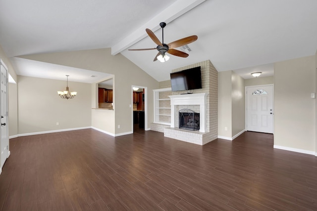 unfurnished living room featuring ceiling fan with notable chandelier, a brick fireplace, dark wood-style floors, and baseboards