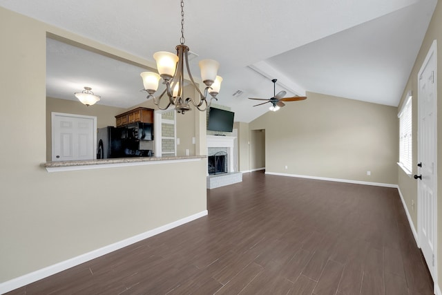 unfurnished living room featuring a fireplace with raised hearth, baseboards, lofted ceiling with beams, ceiling fan with notable chandelier, and dark wood-style flooring