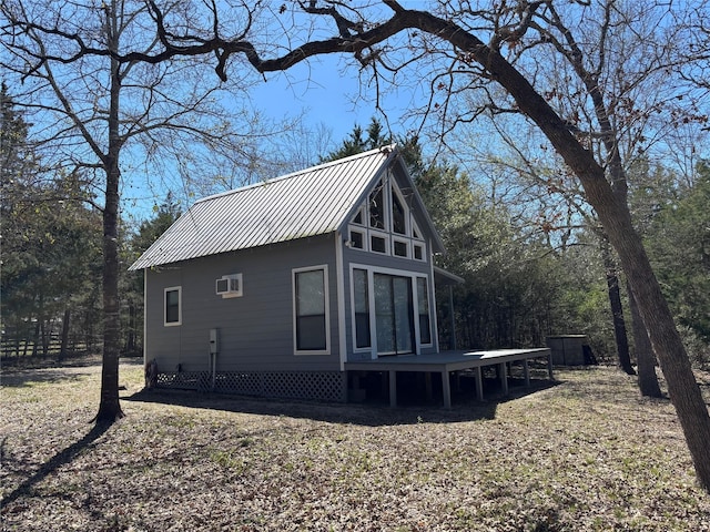 exterior space featuring metal roof, a wall unit AC, and fence