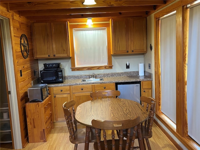 kitchen with dishwashing machine, brown cabinetry, a sink, black microwave, and light wood-type flooring