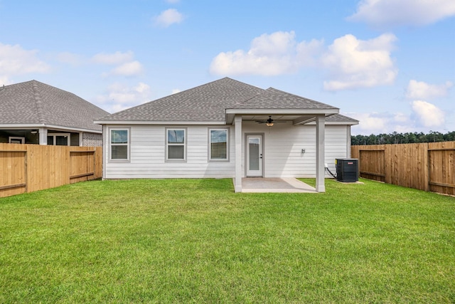 rear view of house featuring a shingled roof, a yard, a fenced backyard, and ceiling fan