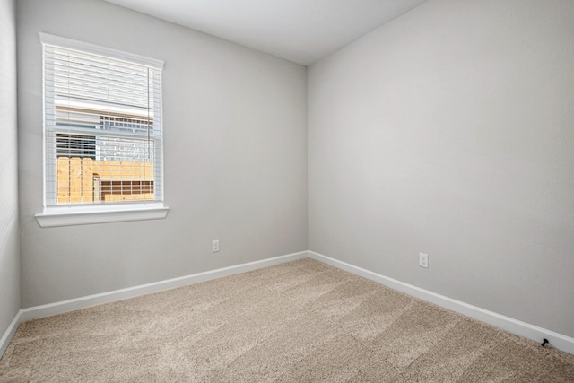 unfurnished room with baseboards and carpet flooring