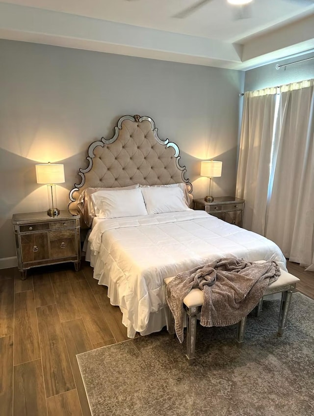 bedroom featuring baseboards and dark wood-style flooring