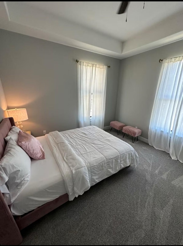 bedroom with multiple windows, a ceiling fan, baseboards, and carpet floors